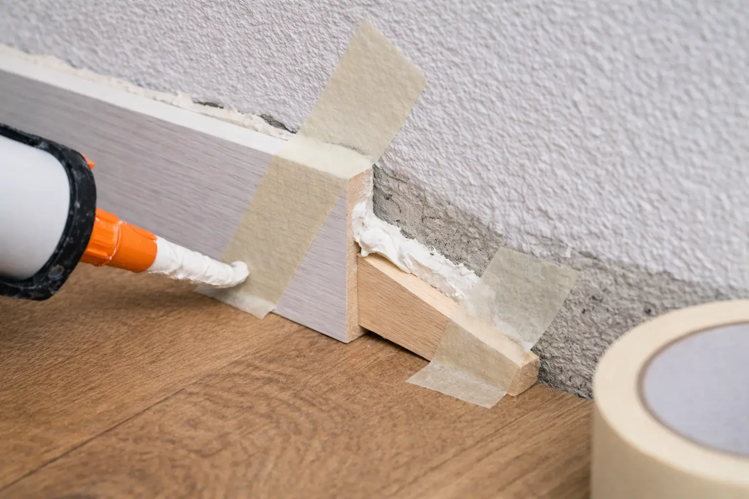 Sockelleisten kleben an unebener Wand mit Montagekleber und Fixierung extra schlecht gemacht