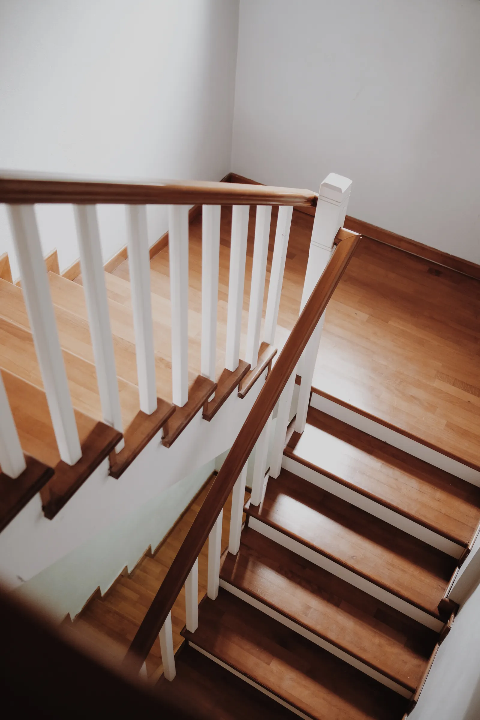 Holztreppe mit weißem Geländer in einem Wohnhaus, Trittstufen aus Holz vor der Treppenrenovierung